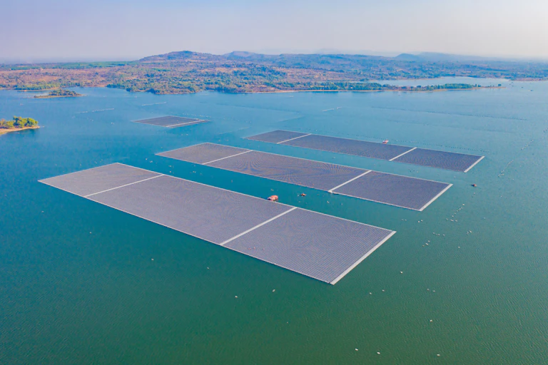 Aerial top view of solar panels or solar cells on buoy floating in lake sea or ocean.