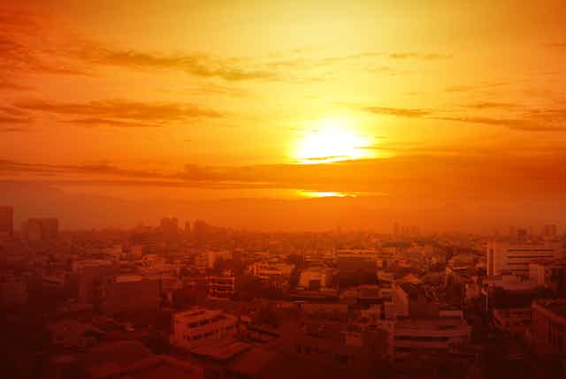 Sun over smoggy cityscape