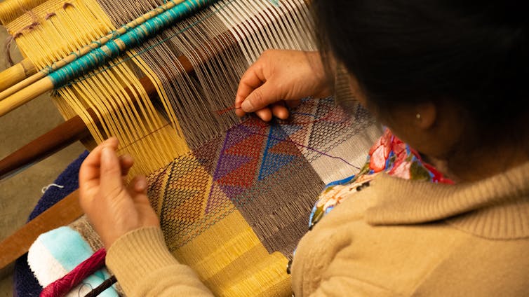 A woman weaving.