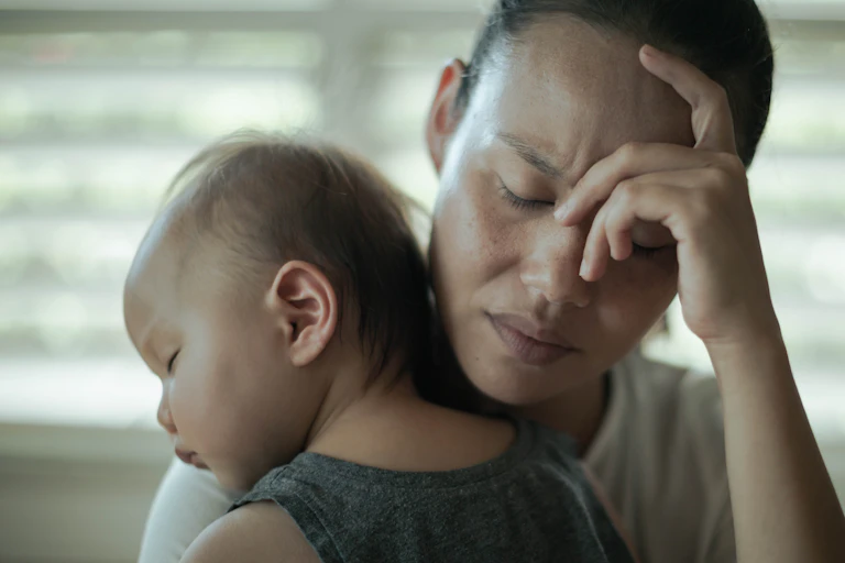 Stressed mother holding a baby