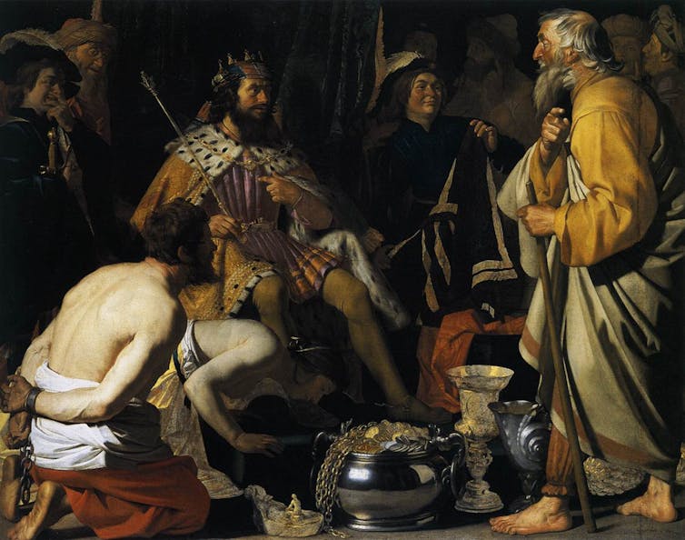 Un rey recibe en su trono a un hombre mayor con barba blanca que le habla mientras un prisionero medio desnudo les observa de rodillas.