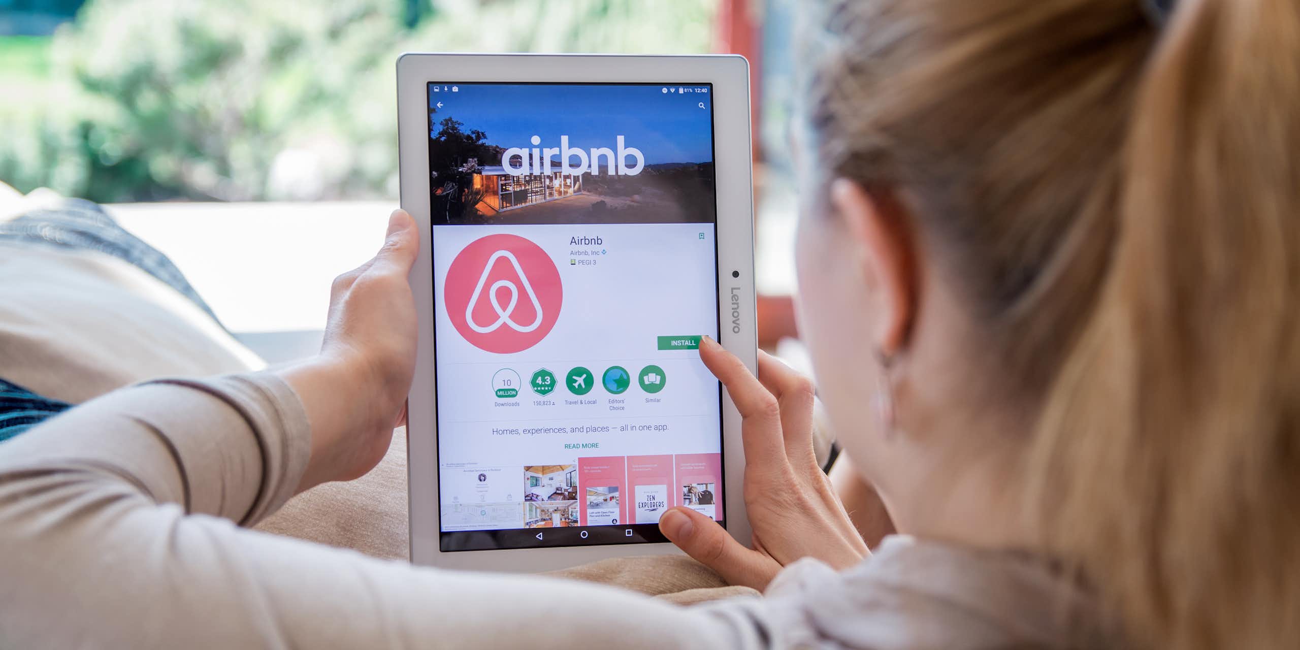 A woman using the Airbnb app on an ipad