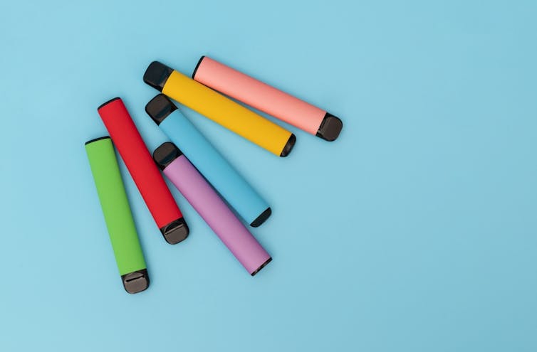 Colourful, disposable vapes on a blue background