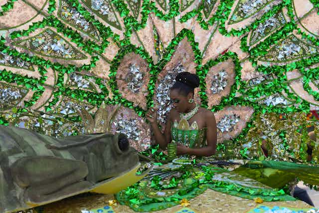 A carnival dancer in a large green costume.