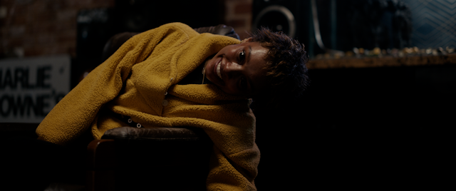 Production image: a teenager in a yellow jumper with fully black eyes.