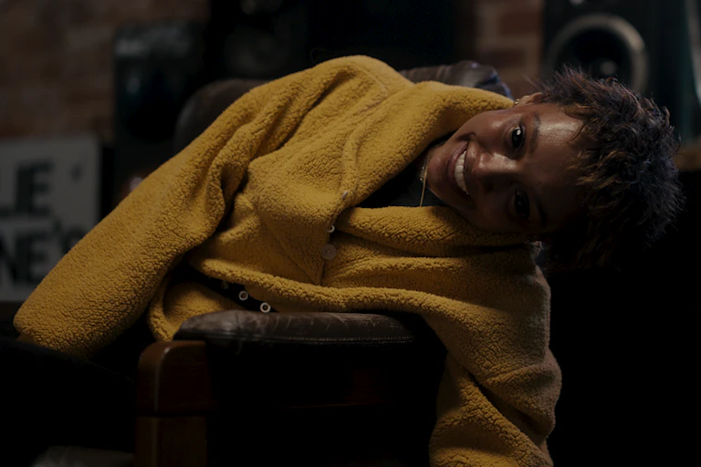 Production image: a teenager in a yellow jumper with fully black eyes.
