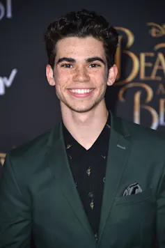 Cameron Boyce in suit smiling at camera.