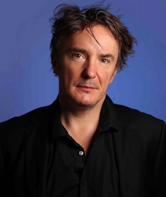 A comical-looking middle-aged Irishman looking bemused at the camera.