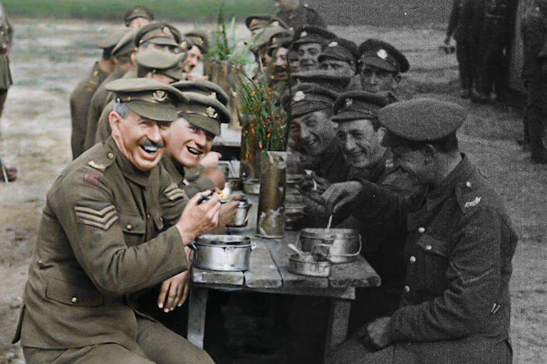 Fotografía de una mesa de cantina con soldados a ambos lados, unos coloreados y otros en blanco y negro.