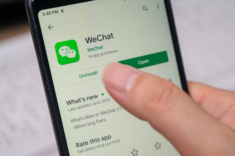 A finger hovering over the uninstall button of the WeChat app on a smartphone
