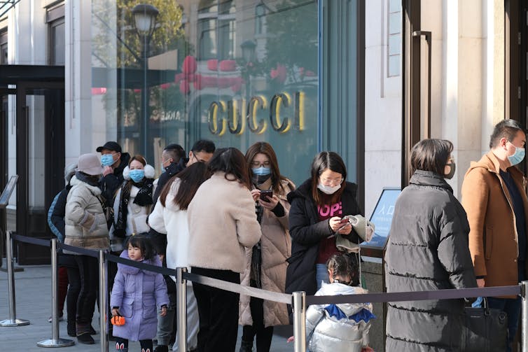 Women queuing to enter a Gucci store.