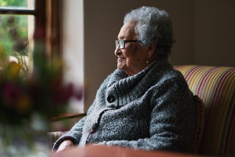 Older woman looks out the window