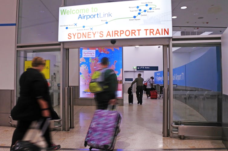 Air travellers enter the airport train station