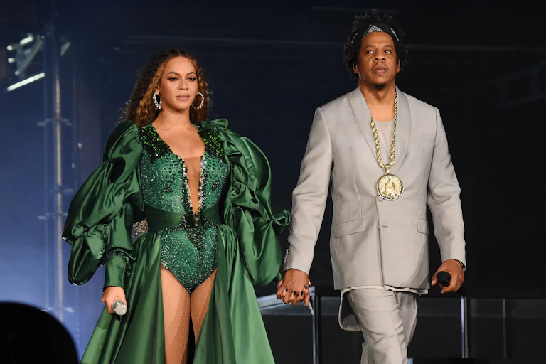 Beyonce and Jay-Z hold hands on stage.