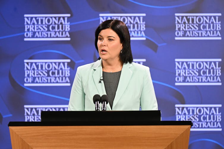 woman stands at lectern