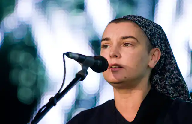 A singer in a head scarf by a microphone.