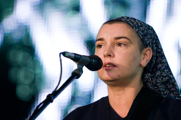 A singer in a head scarf by a microphone.