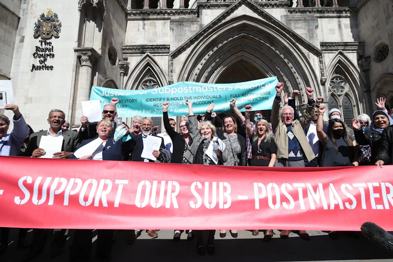 People celebrate outside court holding bannners