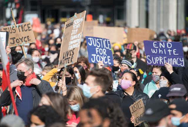 Lors d'une manifestation, des personnes portent des pancartes sur lesquelles on peut lire « Justice for Joyce » en anglais.