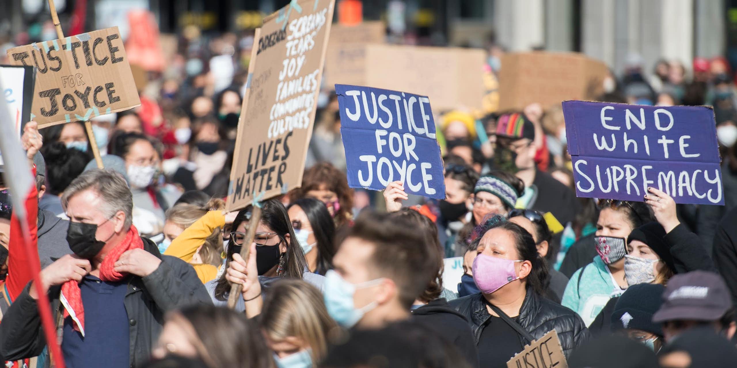 Lors d'une manifestation, des personnes portent des pancartes sur lesquelles on peut lire « Justice for Joyce » en anglais.