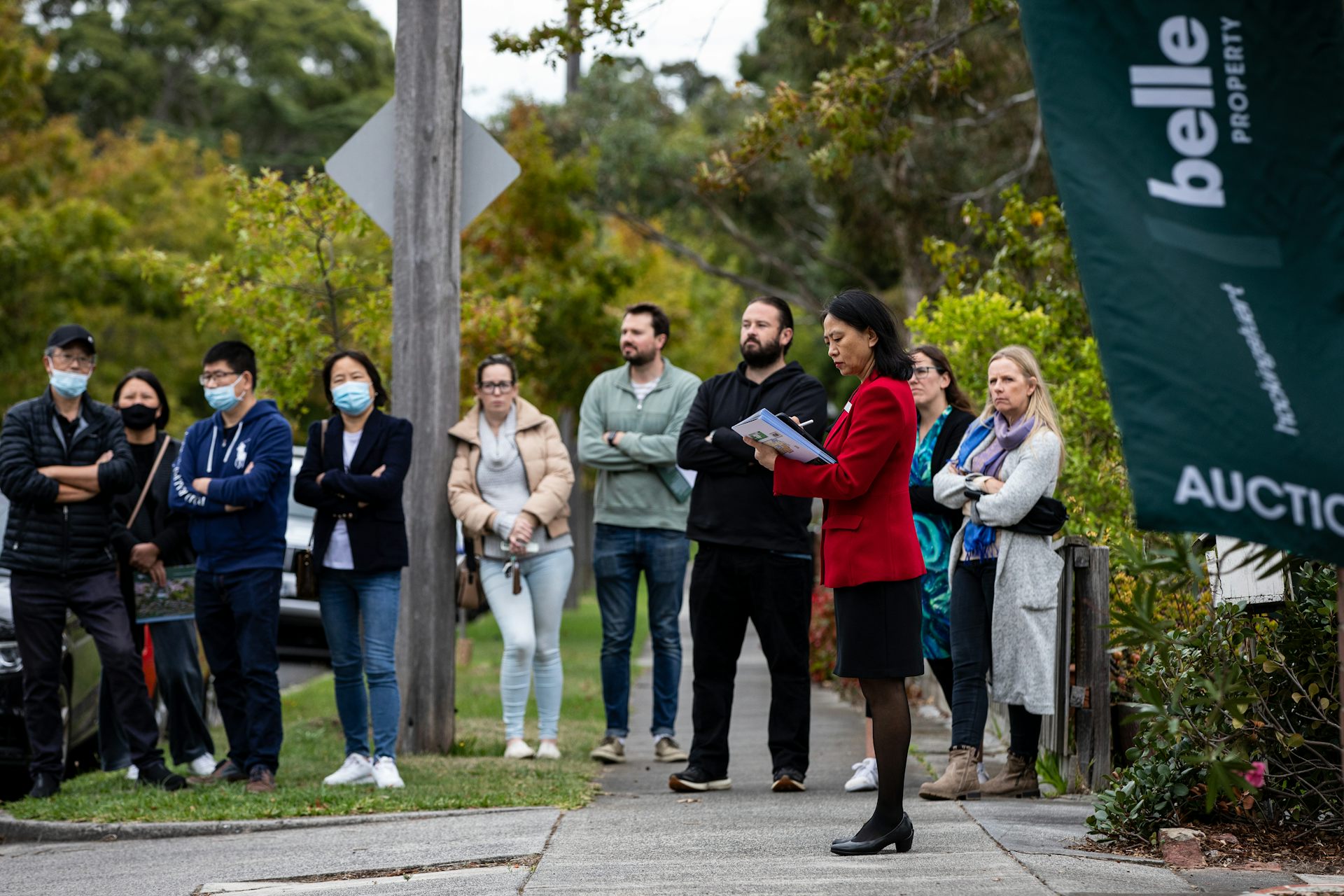 People standing outside a house about to be auctioned