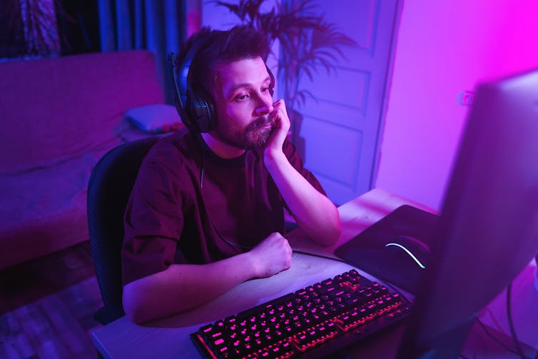 Hombre jugando a un juego de ordenador parece aburrido.