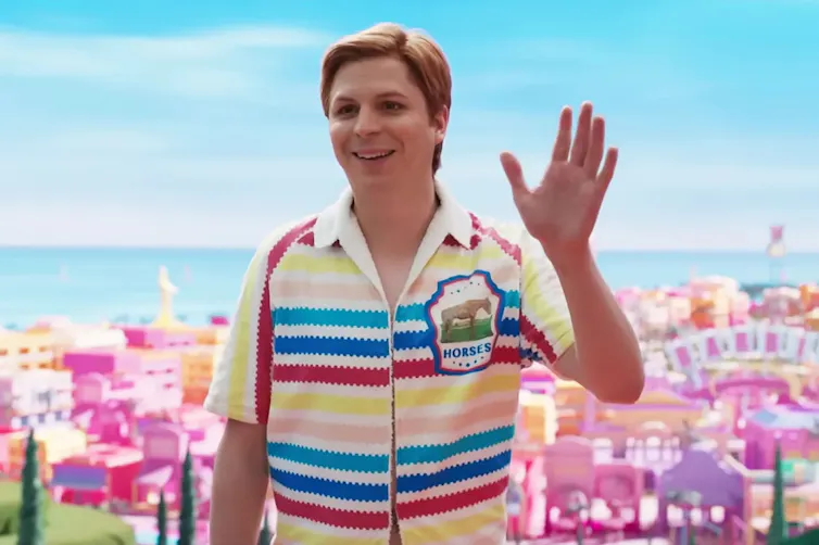 Ken in a striped shirt waves.