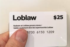 A hand holding a $25 Loblaw gift card