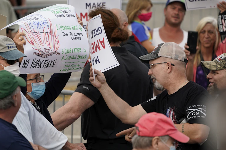 A protester and counter-protester confront each other outside of a campaign rally.