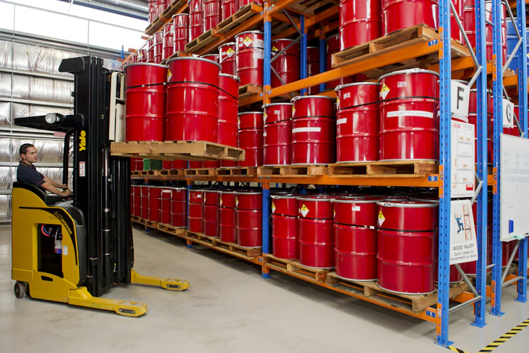 A worker lifts a pallet of nuclear waste, stored in red 44-gallon drums, at the Lucas Heights nuclear reactor site, in Sydney.