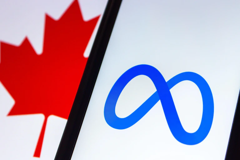 Meta logo on a smartphone with Canadian flag in the background.