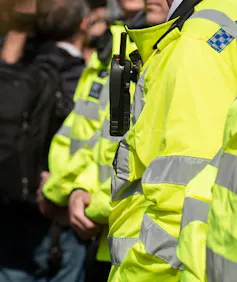 A police officer wearing a yellow high visibility jacket