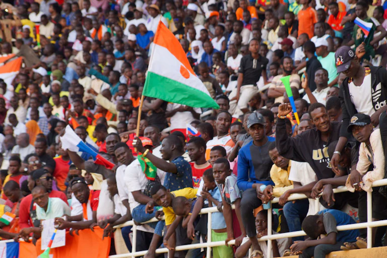 A group of people, some holding national flags