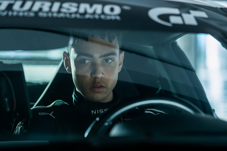 Archie Madekwe sat in a Gran Turismo car.