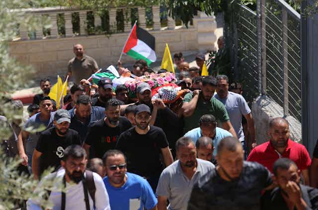 Palestinians attend the funeral of a teenager killed by Israeli settlers in Nablus.