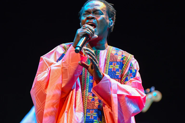 Un homme en grand boubou tient un micro