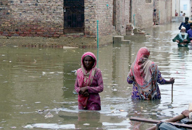 woman walks through flood waters