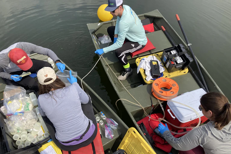 overhead view of four people on two rowboats