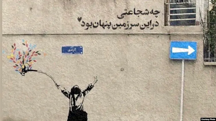 A mural shows a black-and-white figure holding a stick, at the end of which is a colorful plant.