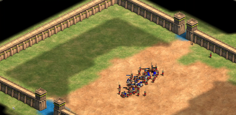 In a video game, a group of nine soldiers in blue are surrounded by a larger group of soldiers in red