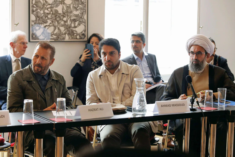Members of Afghan's anti-Taliban coalition including Ahmad Massoud (c) and former cabinet ministers sit at tables at a conference in Vienna, April 2023.