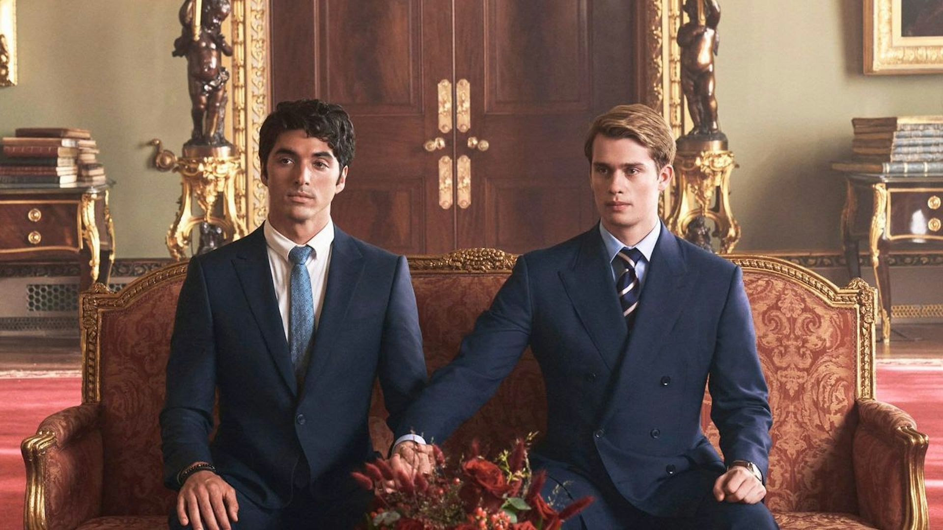Alex and Henry in suits, holding hands.