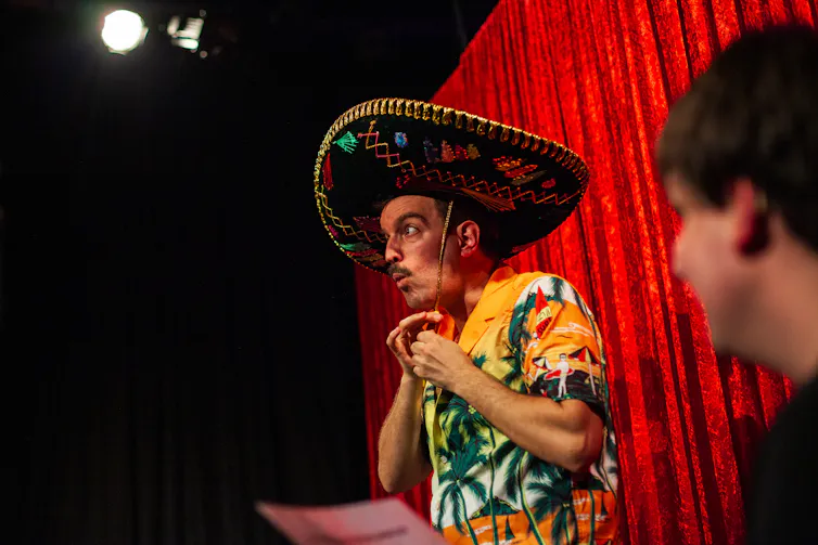 A man on stage in a large sombrero