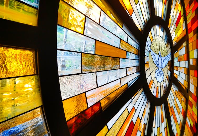 Decorative church stained glass window with dove in the centre