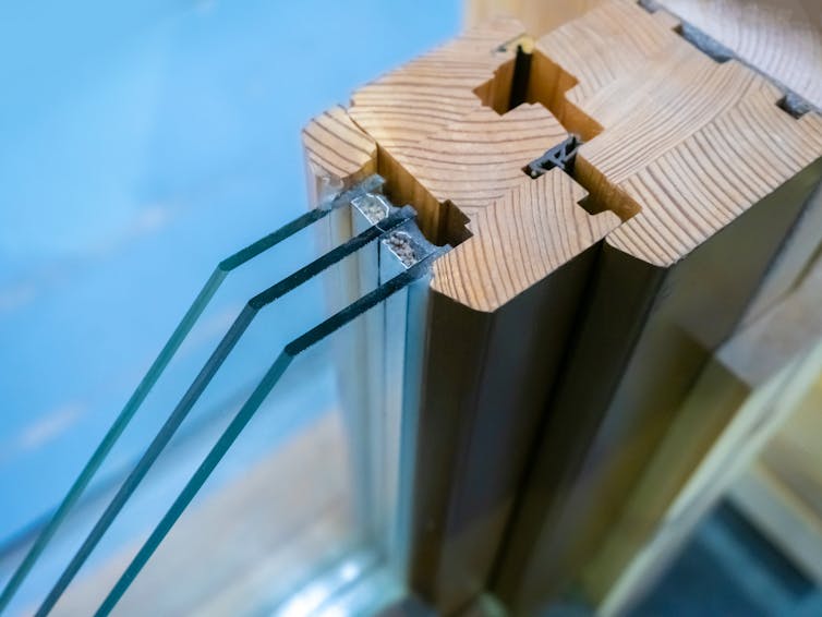 Uma seção transversal de uma moldura de janela mostrando três painéis de vidro.