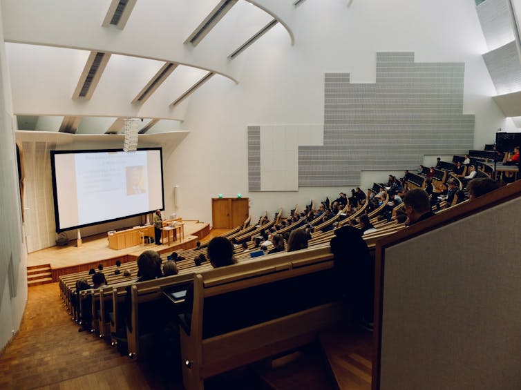 A lecture hall with a man at the front delivering a lecture.