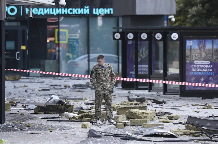 A Russian soldier stands in the rubble of a drone attack on Moscow's central business district