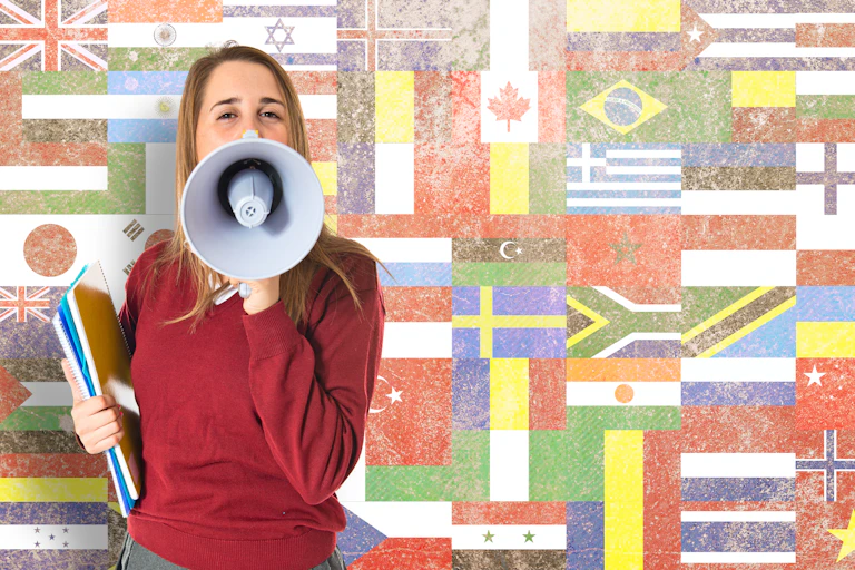 Student shouting by megaphone over flags background.