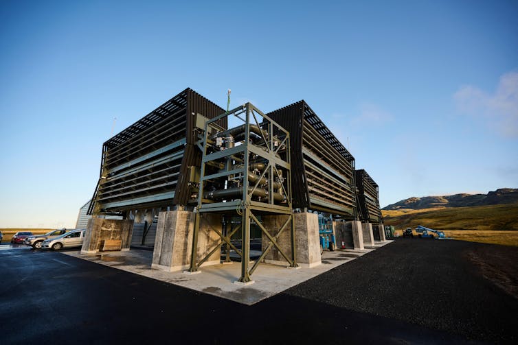 A structure with vents and fans on an empty landscape.