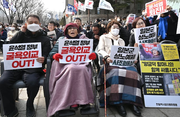 Senior citizens hold signs at a rally